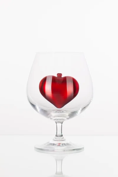 Red heart inside a glass of cognac — Stock Photo, Image