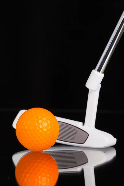 Golf putter et équipements dorés sur le bureau en verre noir — Photo