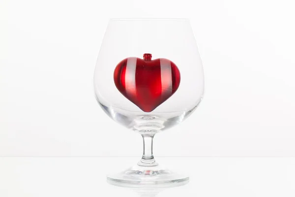 Red heart inside a glass of cognac — Stock Photo, Image