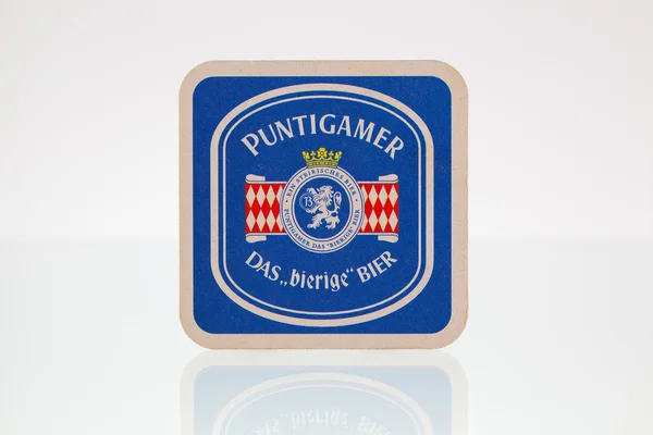 Beermat from Puntigamer beer on a glass table. — Stock Photo, Image