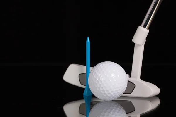 Клюшка для гольфа и золотое оборудование на столе из черного стекла — стоковое фото