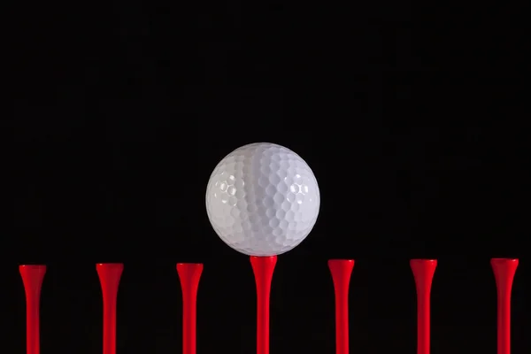 Bola de golfe e tee vermelho — Fotografia de Stock