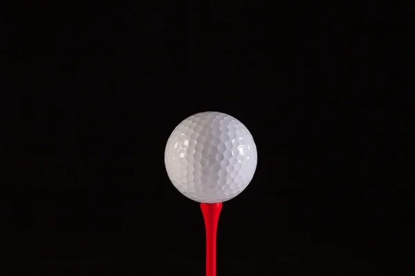 Bola de golfe e tee vermelho — Fotografia de Stock