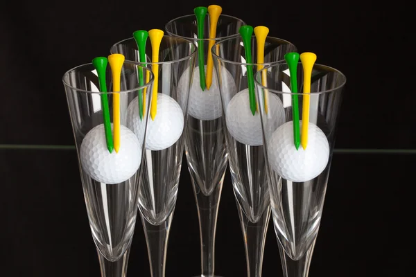 Cinco copos de champanhe e bolas de golfe branco — Fotografia de Stock