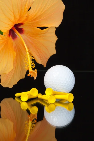 Orange hibiscus flower  and golf equipments on the glass table — Stock Photo, Image