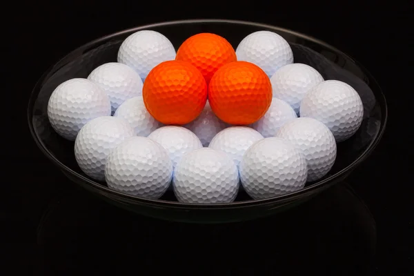 Black ceramic bowl full of golf balls — Stock Photo, Image