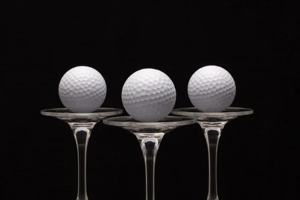Três copos de champanhe e bolas de golfe — Fotografia de Stock
