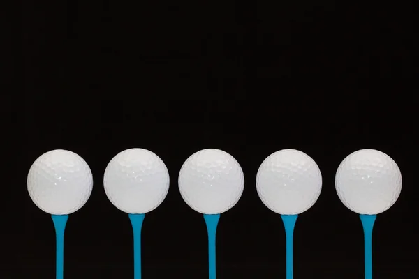 Golfballen op blauwe houten tees — Stockfoto