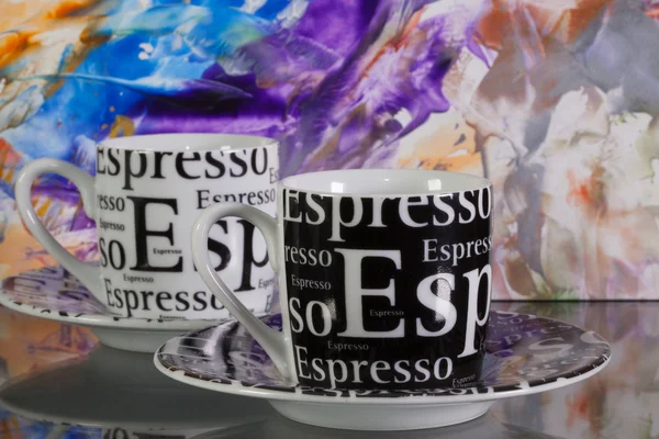 Deux tasses à café vides devant du papier coloré — Photo
