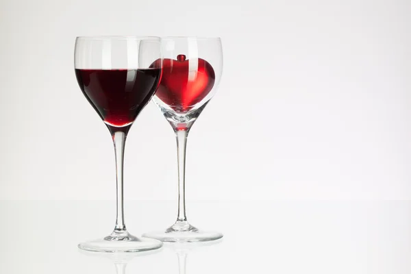 Wine glasses with red wine and heart — Stock Photo, Image