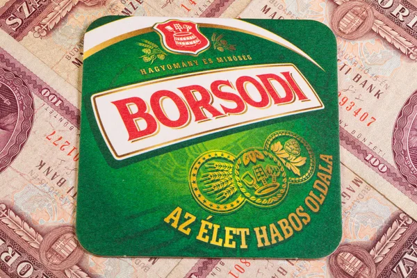 Pivní tácek Borsodi a staré maďarské peníze. — Stock fotografie