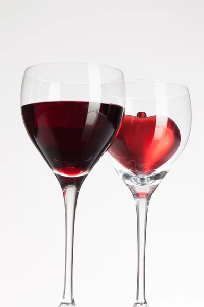 Wine glasses with red wine and heart — Stock Photo, Image