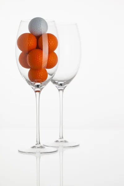Bicchiere da vino con palline da golf — Foto Stock
