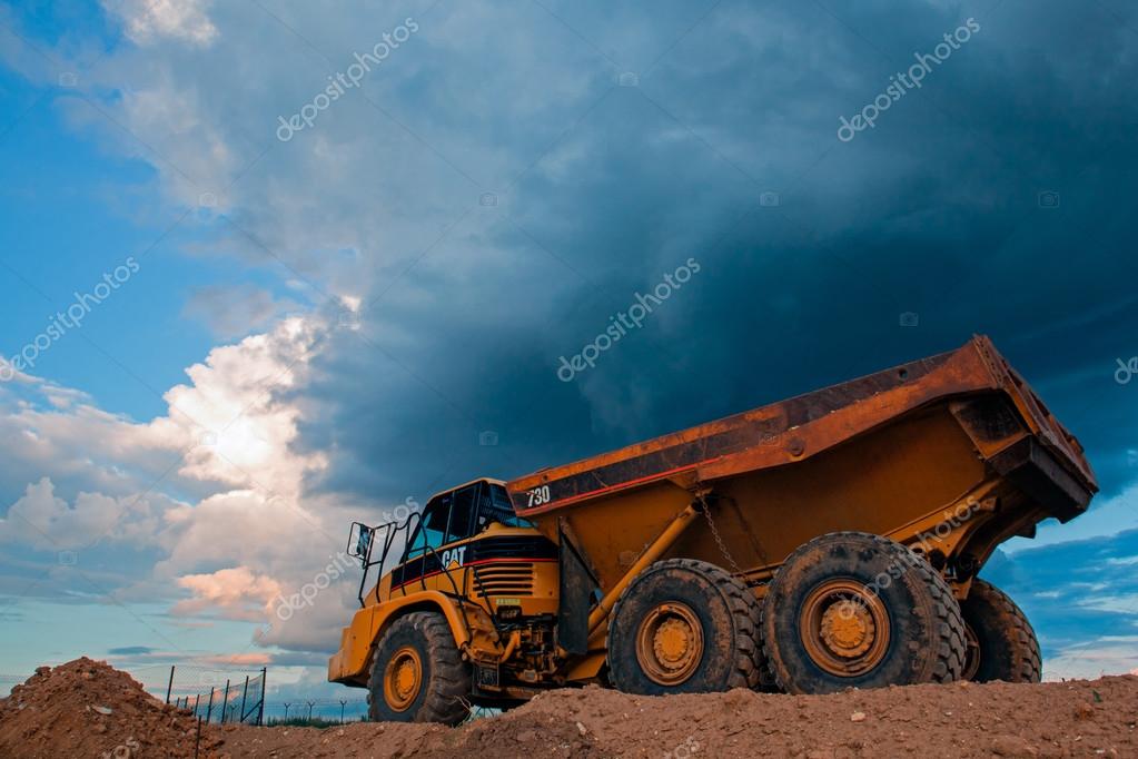 Prague, Czech Republic  - June 14,2011:Yellow Cut truck on the highway construction before heavy storm. The Cat brand is the cornerstone of the Caterpillar brand portfolio, representing products and services made by Caterpillar.