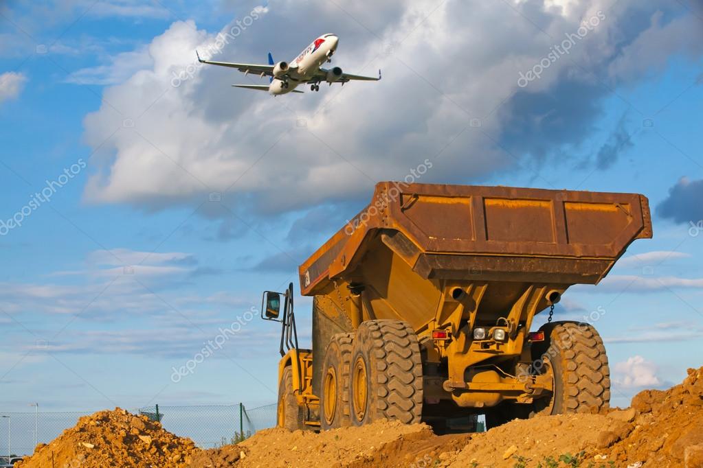 Prague, Czech Republic  - June 14,2011:Yellow Cut truck on the highway construction in front of Ruzyne Airport.The Cat brand is the cornerstone of the Caterpillar brand portfolio, representing products and services made by Caterpillar.