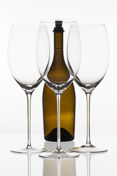 Three empty glasses of wine and brown bottle — Stock Photo, Image