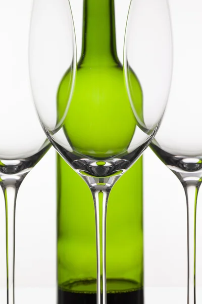 Три пустых бокала вина и зеленая бутылка — стоковое фото