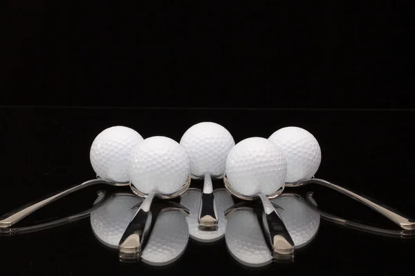 Five spoons and golf balls — Stock Photo, Image