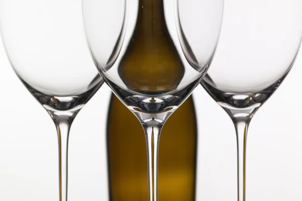 Three empty glasses of wine and brown bottle — Stock Photo, Image