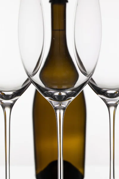 Três copos vazios de vinho e garrafa marrom — Fotografia de Stock
