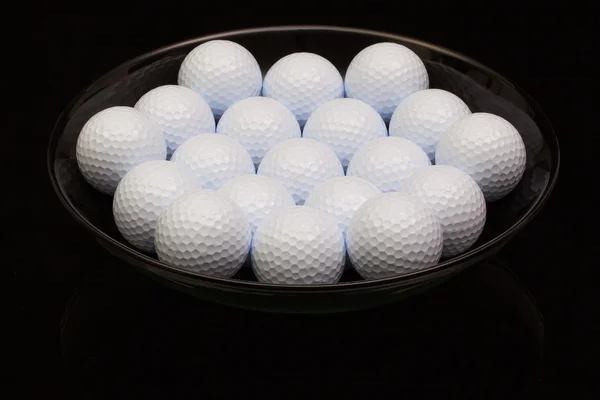 Tigela de cerâmica preta cheia de bolas de golfe — Fotografia de Stock