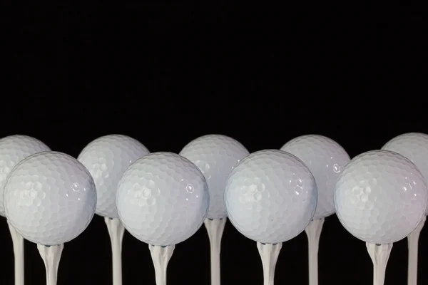 White golf balls on a white tees — Stok fotoğraf