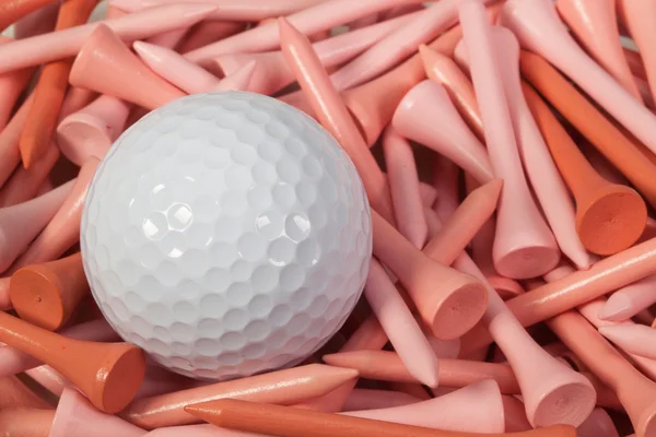 Белый мяч для гольфа, лежащий между деревянными досками — стоковое фото