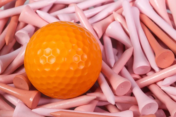 Naranja pelota de golf acostado entre tees de madera —  Fotos de Stock