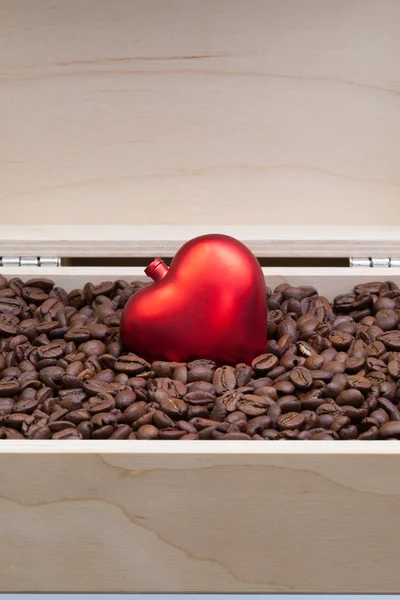 Кофейные зерна и красное сердце в открытой коробке — стоковое фото