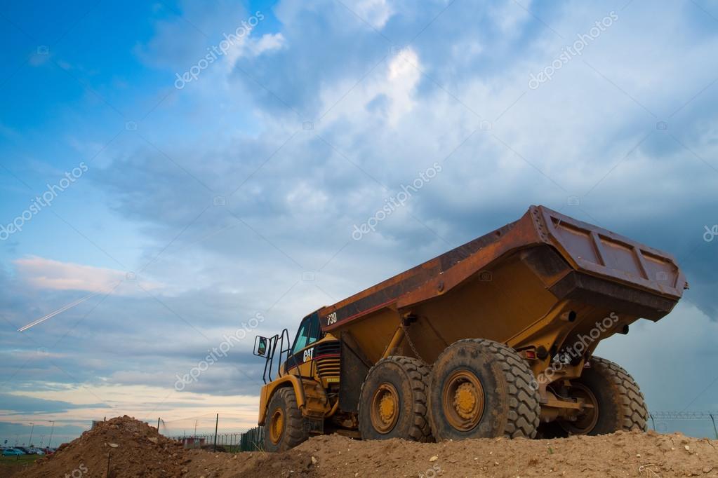 Prague Czech Republic - June 14, 2011:Yellow Cut truck on the highway construction before heavy storm. The Cat brand is the cornerstone of the Caterpillar brand portfolio representing products and services made by Caterpillar.