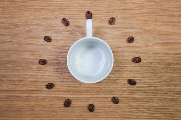 Empty coffee cup and clock of coffee beans