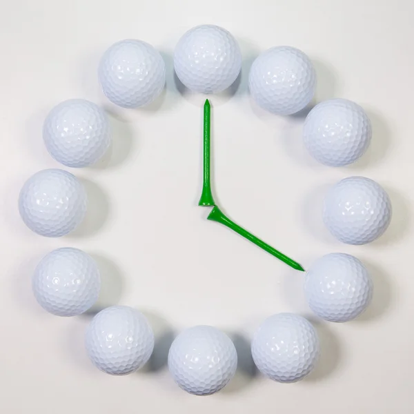 De klok van golfballen en houten tees — Stockfoto