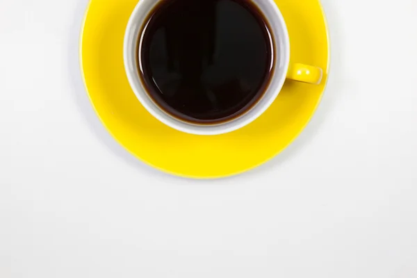 Yellow cup of coffee on a white table — Stock Photo, Image