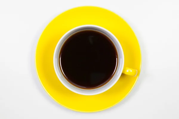 Yellow cup of coffee on a white table — Stock Photo, Image