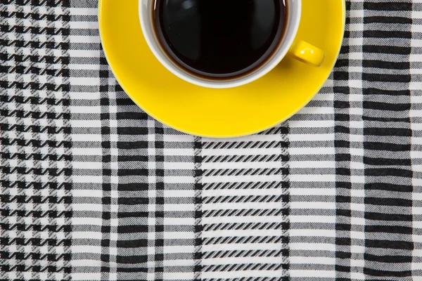 Yellow cup of coffee and Arab scarf on a table — Stock Photo, Image