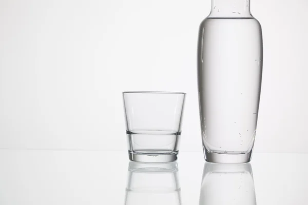 Pohár vizet az üveg asztalra — Stock Fotó