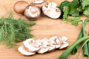 Doğranmış mantarlar, yeşil soğanlar, maydanoz ve dereotlu ahşap bir arka planda mesaj için yer var. Kapatın. Kırsal biçim.