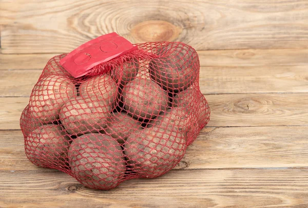木製の背景に赤いグリッド内のジャガイモ. — ストック写真