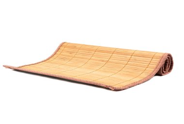 Beyaz arka planda yarım yamalak kahverengi bambu yemek paspası. Geleneksel mutfak aletleri.