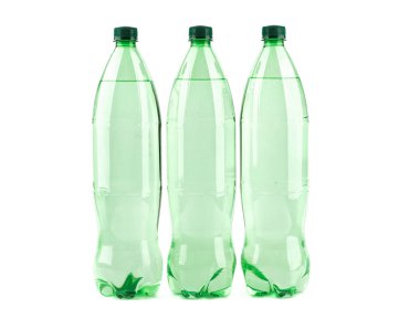 Beyaz zemin üzerinde maden suyu olan üç plastik şişe..