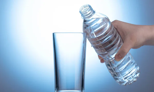 Botol plastik dengan air di tangan wanita. — Stok Foto