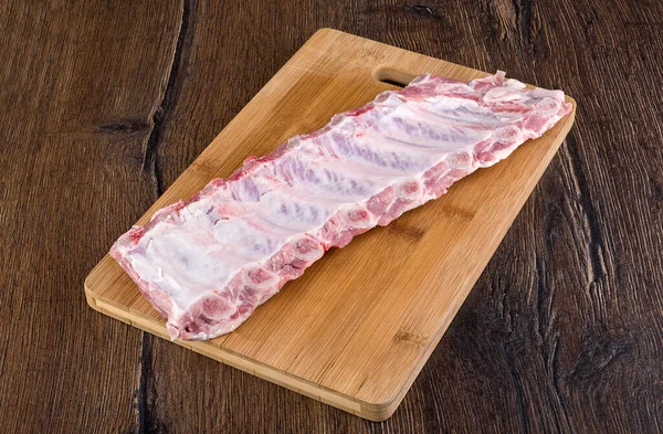 Tahta kesme tahtasında çiğ domuz pirzolası. Kapatın. Boşluğu kopyala.