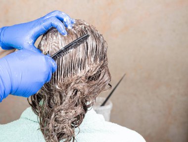 Kadın saçında tarak ile boya dağılımı. Saç bakımı. Boşluğu kopyala.