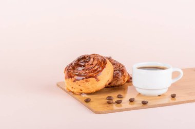 İki tarçınlı çörek ve bir fincan kahve. Ev yapımı çörekler..