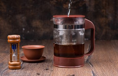 Çaydanlığa sıcak su döküyorum. Çaydanlığın cam kasesi buğulandı. Çay demliyorum..