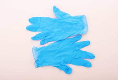 Bir çift mavi koruyucu eldiven, bej arka planda izole edilmiş. Uzayı kopyala Düz yatıyordu.