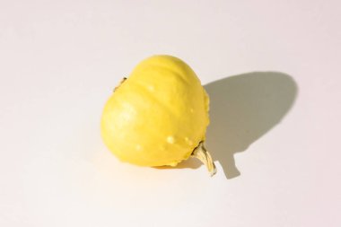 A small yellow decorative pumpkin lies on its side. Copy space.
