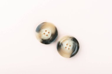 Two brown and black plastic buttons on both sides.
