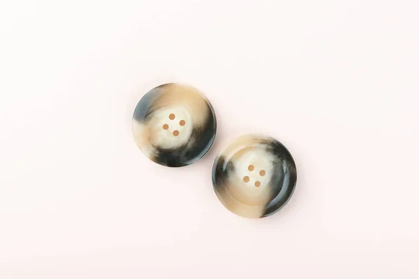 Two brown and black plastic buttons on both sides.