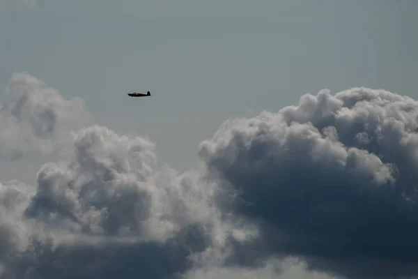 多云的天空中一架轻型飞机的轮廓 — 图库照片